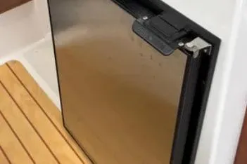 Slide: The Image of 2019 Cutwater C-24 Coupe interior with stainless steel fridge and wooden flooring. - 33