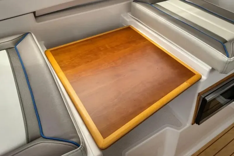 Slide: The Image of Interior of 2019 Cutwater C-24 Coupe featuring a wooden table and cushioned seating. - 34