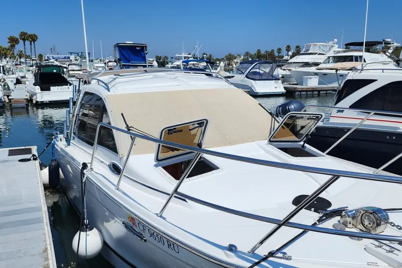Slide: The Image of 2019 Cutwater C-24 Coupe docked at a marina with other boats in the background. - 4