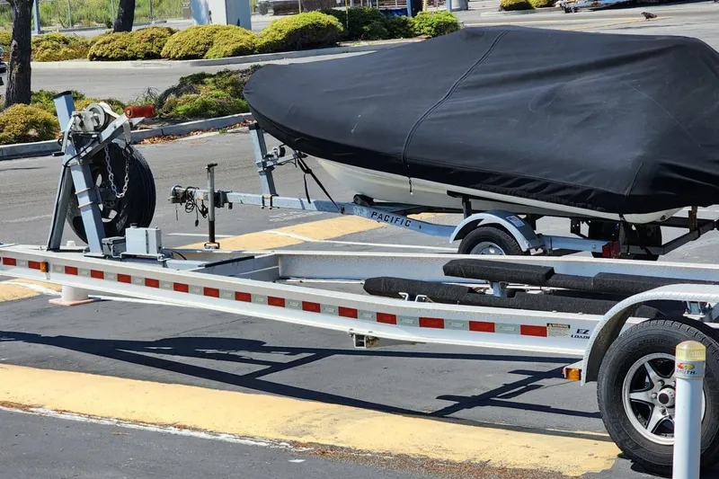 Slide: The Image of 2019 Cutwater C-24 Coupe boat on trailer, covered with black tarp in parking lot. - 46