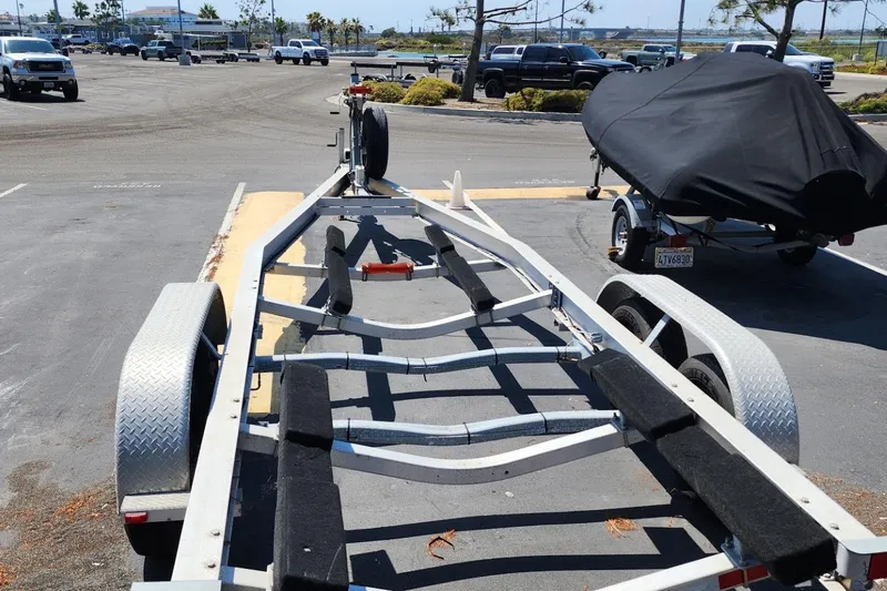 Slide: The Image of Trailer for 2019 Cutwater C-24 Coupe in parking lot, covered boat nearby. - 48