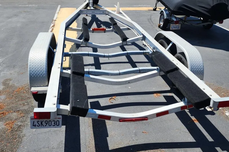 Slide: The Image of Boat trailer for 2019 Cutwater C-24 Coupe, parked on asphalt, with dual axles and metal fenders. - 49