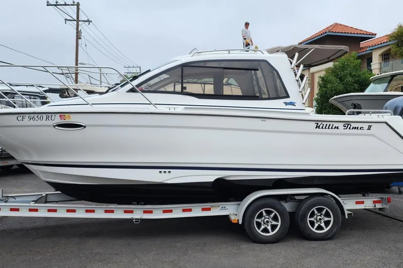 Slide: The Image of 2019 Cutwater C-24 Coupe boat on trailer, named "Killin Time II." - 52