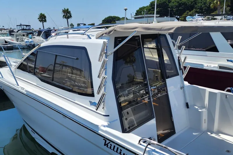 Slide: The Image of 2019 Cutwater C-24 Coupe docked at marina, featuring sleek design and spacious cockpit. - 6