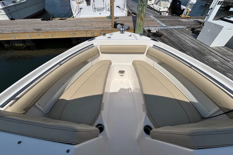 Slide: The Image of 2017 Pursuit DC 235 Dual Console boat with beige seating at dock. - 11