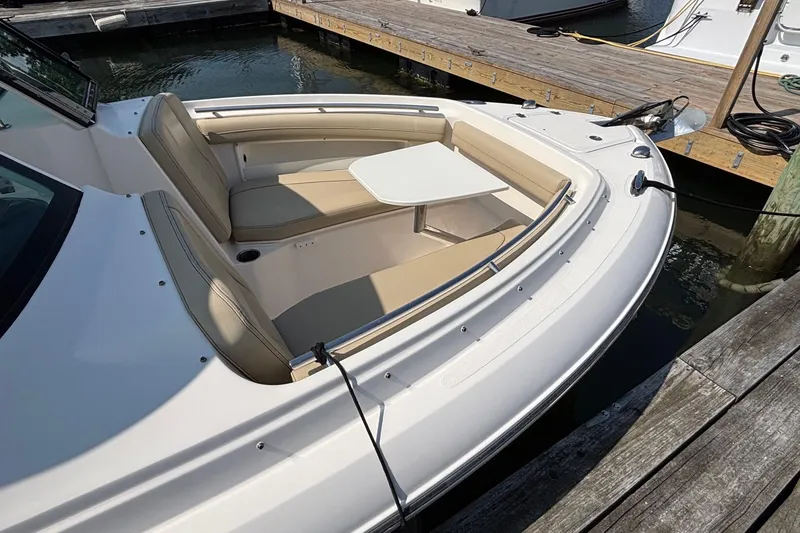 Slide: The Image of 2017 Pursuit DC 235 Dual Console boat with seating and table at dock. - 12