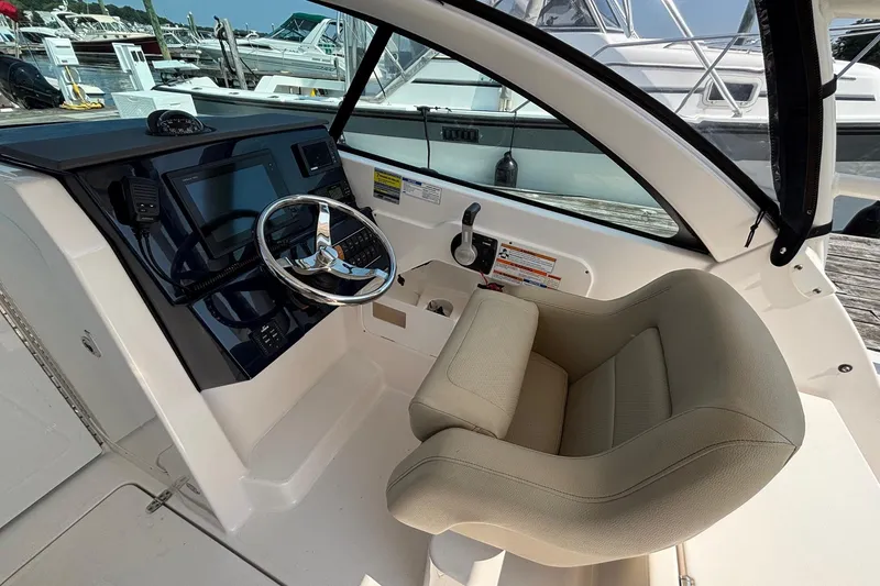 Slide: The Image of 2017 Pursuit DC 235 Dual Console boat interior with steering wheel and control panel. - 13