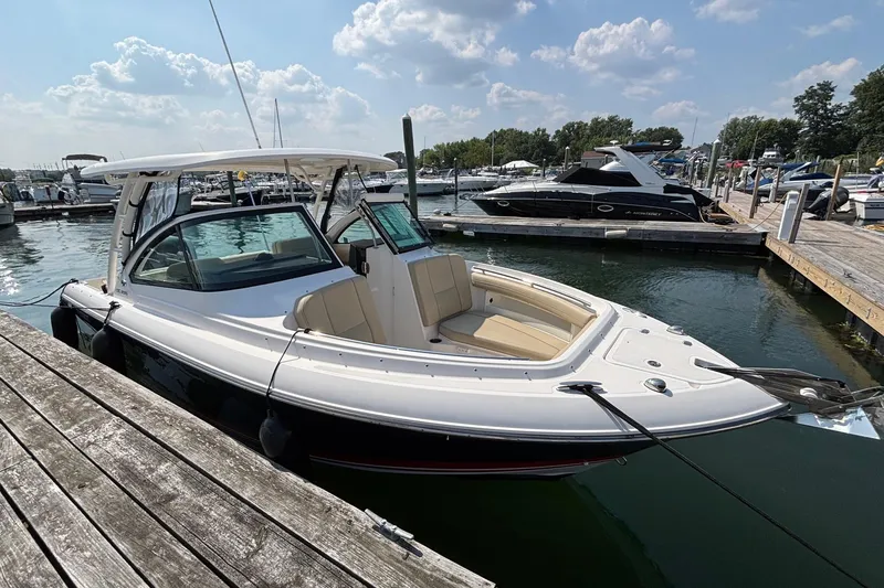Slide: The Image of 2017 Pursuit DC 235 Dual Console boat docked at marina under clear sky. - 2