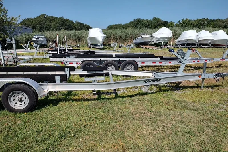 Slide: The Image of Boat trailers on grassy lot, featuring Pursuit DC 235 Dual Console, 2017 model. - 26