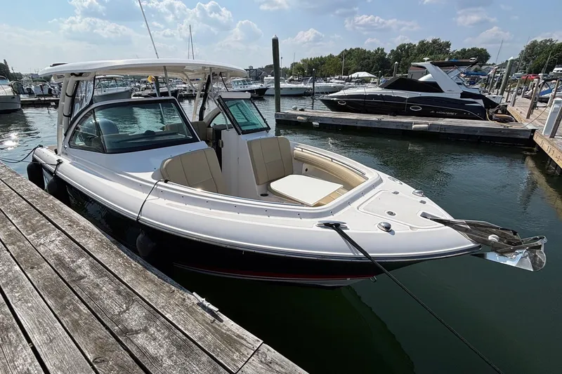 Slide: The Image of 2017 Pursuit DC 235 Dual Console boat docked at marina under sunny skies. - 3