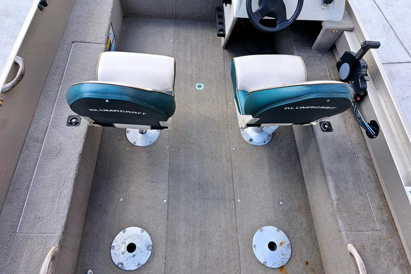 Slide: The Image of 2000 Alumacraft Navigator 165 CS boat interior with two seats and steering wheel. - 10