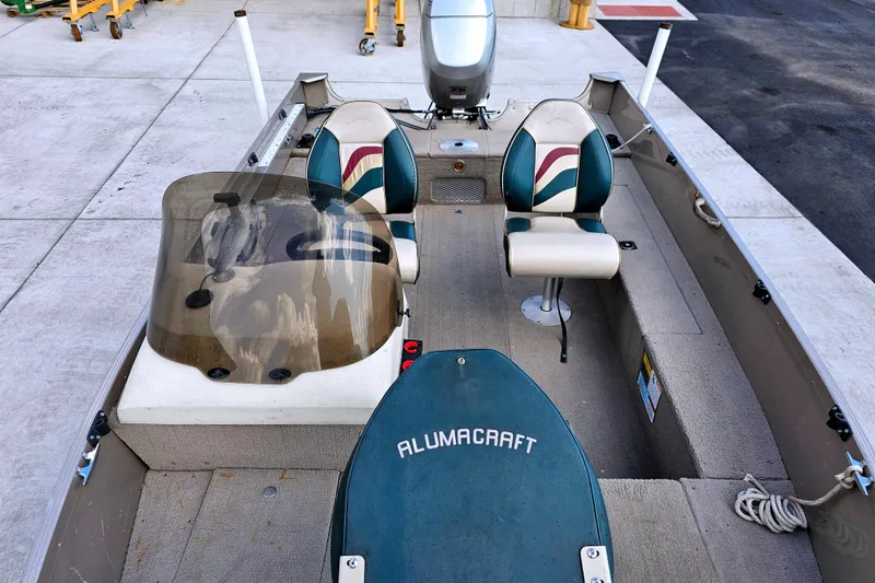 Slide: The Image of 2000 Alumacraft Navigator 165 CS boat interior with seating and steering console. - 12