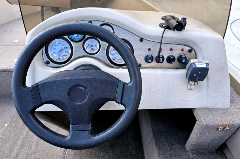 Slide: The Image of Steering console of 2000 Alumacraft Navigator 165 CS boat with gauges and controls. - 13