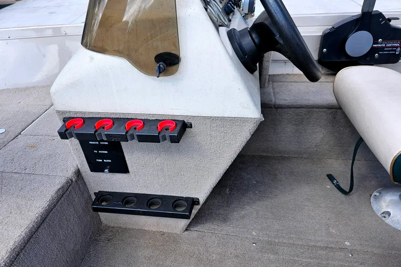 Slide: The Image of 2000 Alumacraft Navigator 165 CS boat dashboard with steering wheel and control panel. - 16