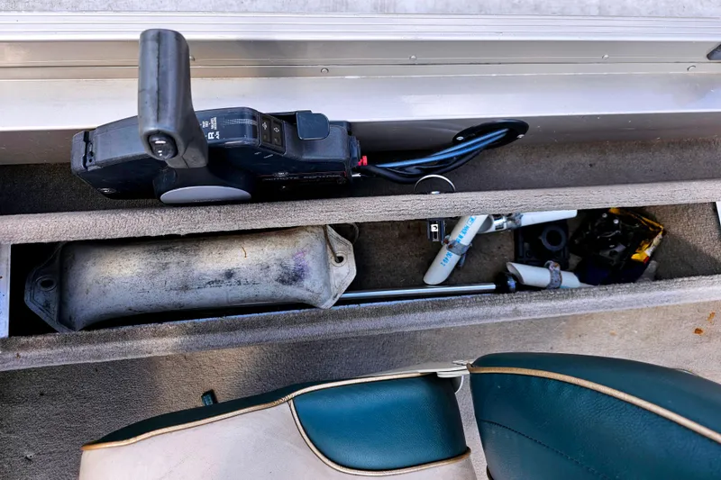 Slide: The Image of Storage compartment in a 2000 Alumacraft Navigator 165 CS boat with various equipment. - 17