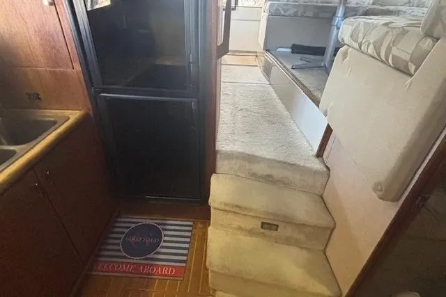 Slide: The Image of Interior of 1990 Bayliner 3888 yacht with stairs, kitchenette, and welcome mat. - 10