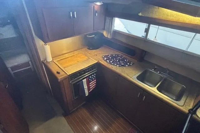 Slide: The Image of Interior of 1990 Bayliner 3888 yacht kitchen with wooden cabinets and dual sink. - 12