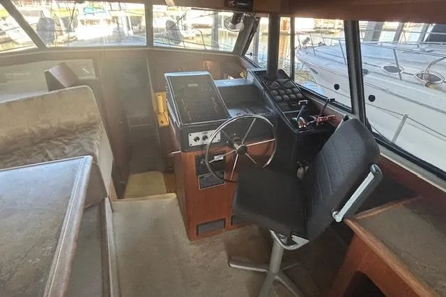 Slide: The Image of 1990 Bayliner 3888 boat interior with steering wheel and navigation equipment. - 13