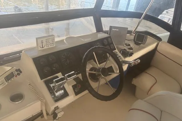 Slide: The Image of 1990 Bayliner 3888 boat cockpit with steering wheel, controls, and navigation equipment. - 26