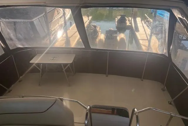 Slide: The Image of Interior view of a 1990 Bayliner 3888 boat with seating and a small table. - 27