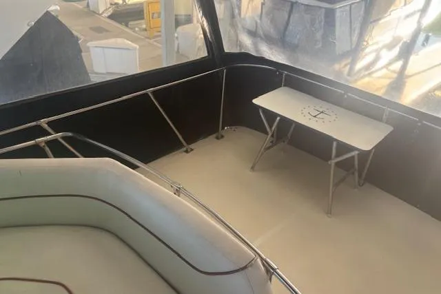 Slide: The Image of 1990 Bayliner 3888 boat interior with seating and a small table. - 28