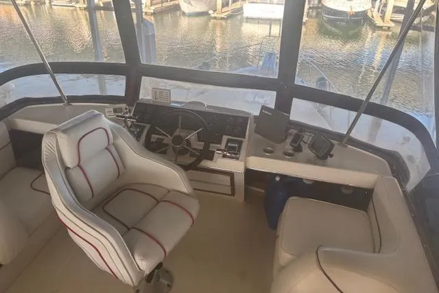 Slide: The Image of Interior view of 1990 Bayliner 3888 boat cockpit with steering wheel and seating. - 32