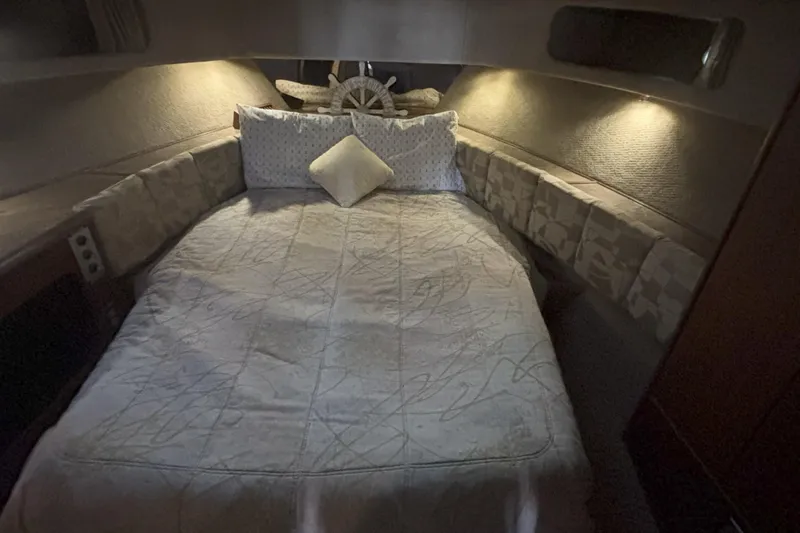 Slide: The Image of Cozy cabin interior of 1990 Bayliner 3888 with comfortable bedding and ambient lighting. - 4