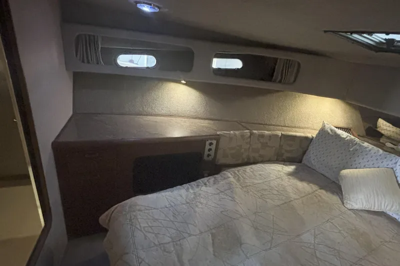 Slide: The Image of Cozy cabin interior of 1990 Bayliner 3888 yacht with bed and ambient lighting. - 5