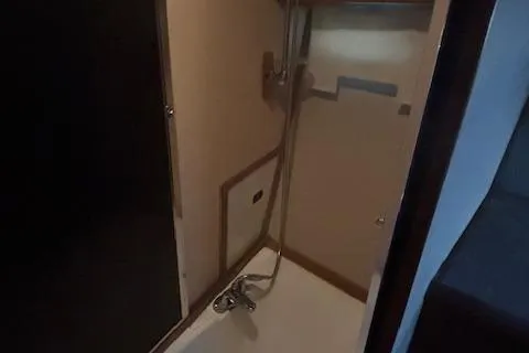 Slide: The Image of 1990 Bayliner 3888 yacht shower area with modern fixtures and compact design. - 6