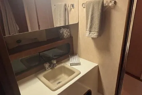 Slide: The Image of 1990 Bayliner 3888 bathroom with sink, mirror, and towel rack. - 7
