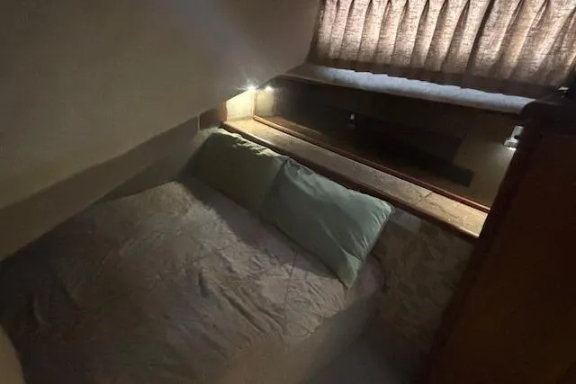 Slide: The Image of Cozy cabin interior of 1990 Bayliner 3888 with bed and soft lighting. - 9