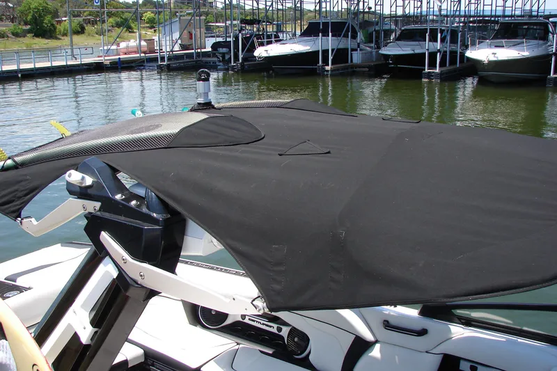 Slide: The Image of 2019 Centurion Ri257 boat with black cover docked at marina. - 19