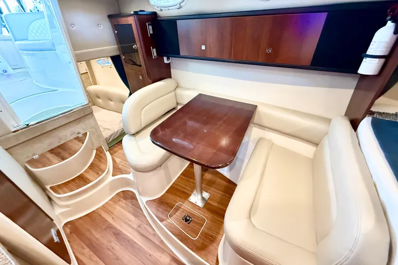 Slide: The Image of 2016 Chaparral 290 Signature cabin interior with dining area and wooden table. - 21