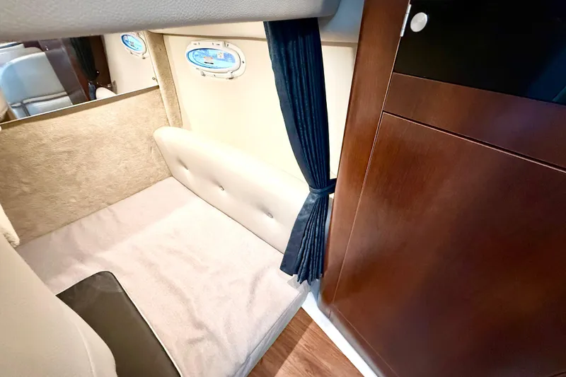 Slide: The Image of 2016 Chaparral 290 Signature cabin interior with cozy sleeping area and elegant wood finish. - 24