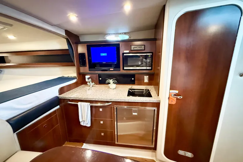 Slide: The Image of 2016 Chaparral 290 Signature yacht interior with kitchenette, microwave, and cozy sleeping area. - 27