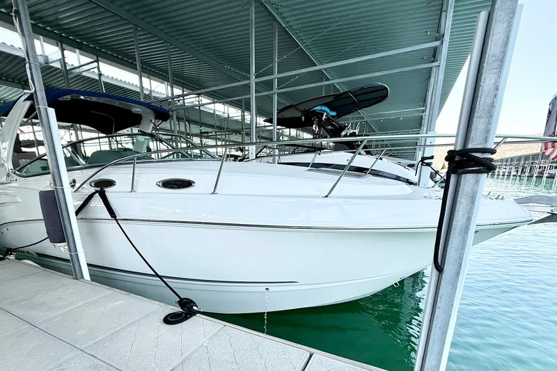 Slide: The Image of 2016 Chaparral 290 Signature boat docked in a marina under a covered structure. - 3
