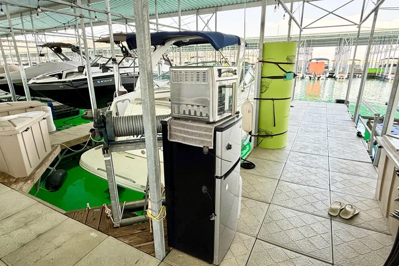 Slide: The Image of 2016 Chaparral 290 Signature docked, with nearby appliances and green water mat. - 37