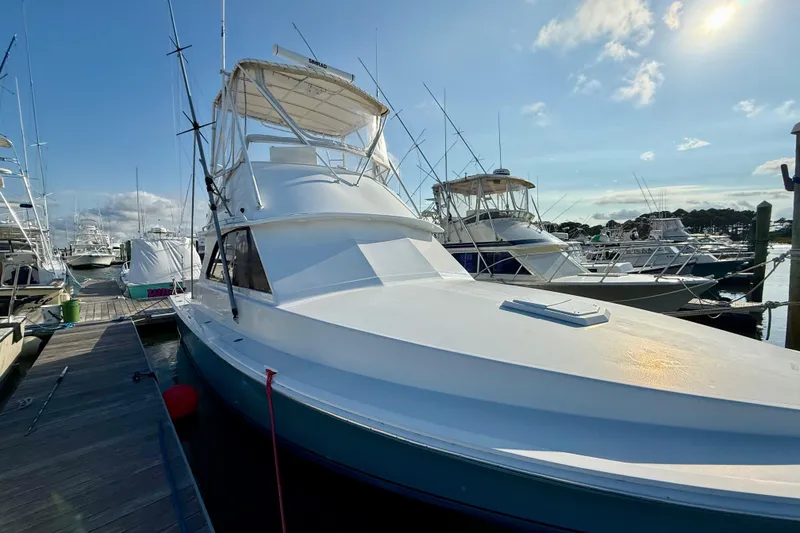 Slide: The Image of 1979 Bertram 35 Flybridge yacht docked at marina under clear blue sky. - 10