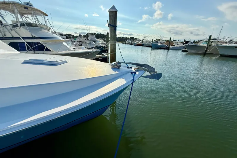 Slide: The Image of 1979 Bertram 35 Flybridge yacht docked in a marina under a clear sky. - 11