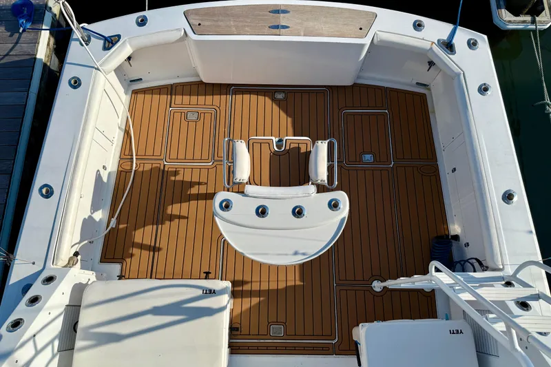 Slide: The Image of 1979 Bertram 35 Flybridge boat deck with teak flooring and fishing chair. - 15