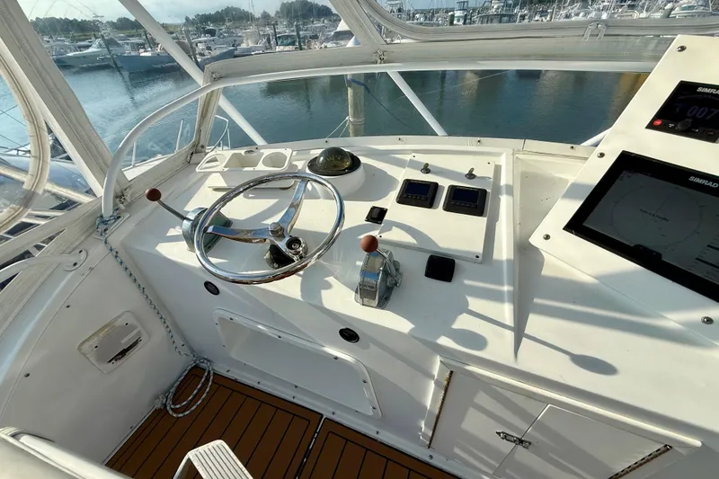 Slide: The Image of 1979 Bertram 35 Flybridge helm with steering wheel, controls, and navigation equipment. - 18