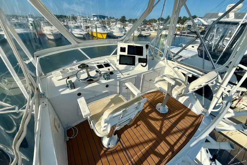Slide: The Image of 1979 Bertram 35 Flybridge helm with wooden deck, marina view, and navigational equipment. - 20