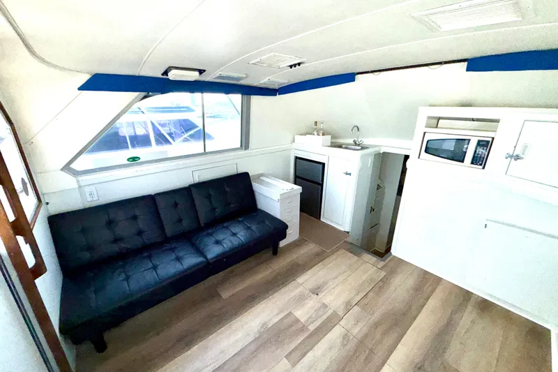 Slide: The Image of Interior of 1979 Bertram 35 Flybridge with sofa, kitchenette, and wood flooring. - 23