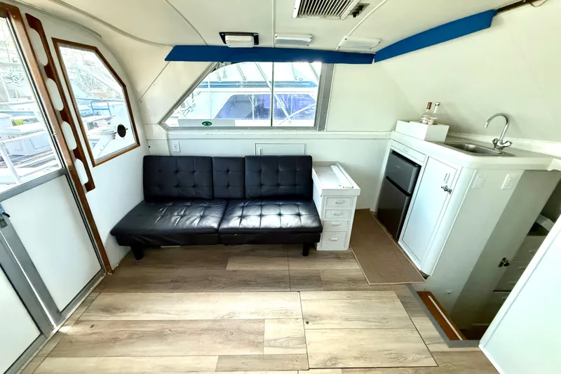 Slide: The Image of Interior of 1979 Bertram 35 Flybridge with sofa, kitchenette, and wood flooring. - 24