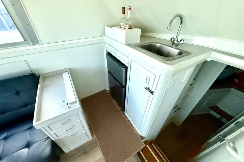 Slide: The Image of 1979 Bertram 35 Flybridge interior with compact kitchenette and seating area. - 25