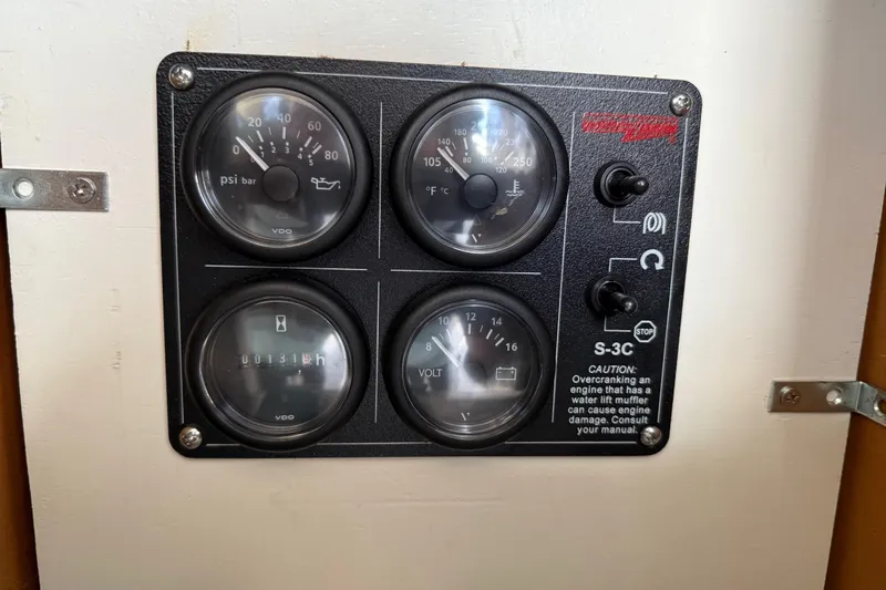 Slide: The Image of 1979 Bertram 35 Flybridge engine control panel with gauges and caution label. - 29