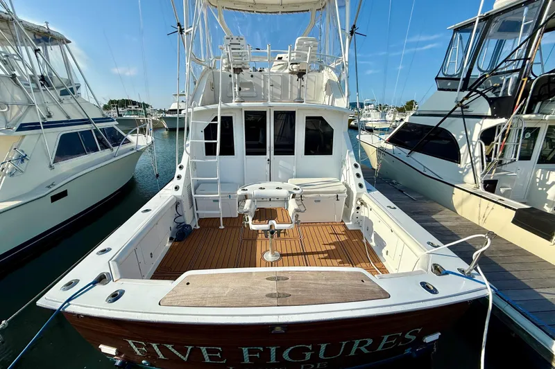 Slide: The Image of 1979 Bertram 35 Flybridge boat docked, showcasing spacious deck and fishing equipment. - 3