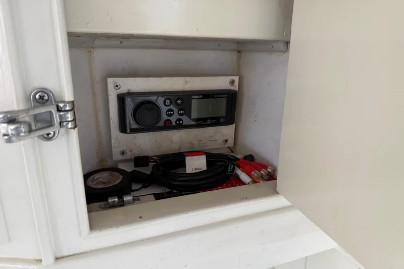 Slide: The Image of 1979 Bertram 35 Flybridge audio system with cables in a cabinet. - 30