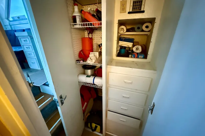 Slide: The Image of 1979 Bertram 35 Flybridge storage closet with shelves and supplies. - 34