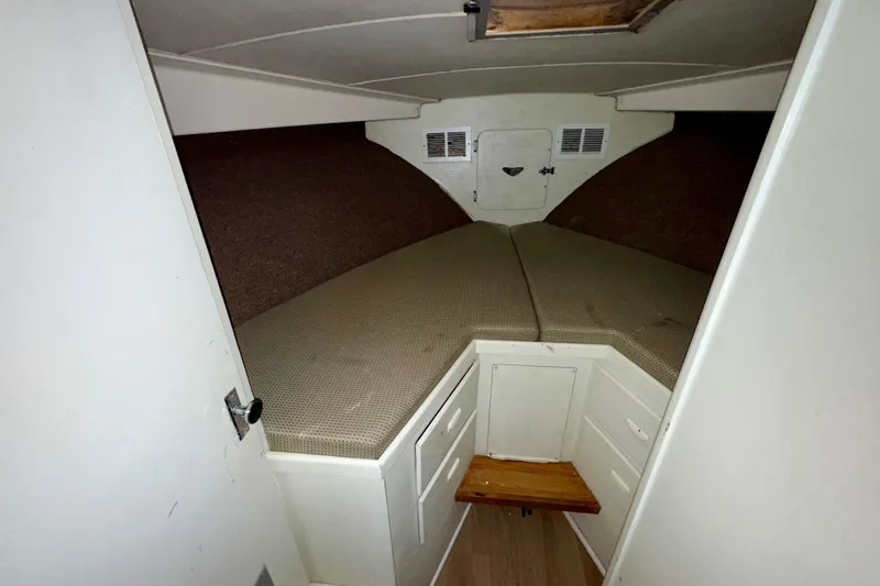 Slide: The Image of 1979 Bertram 35 Flybridge cabin interior with V-berth and storage compartments. - 35